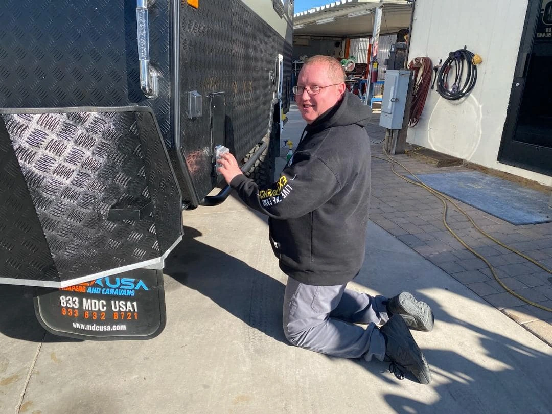 Arizona RV Service technician repairing camper power hookup outside Mesa repair shop